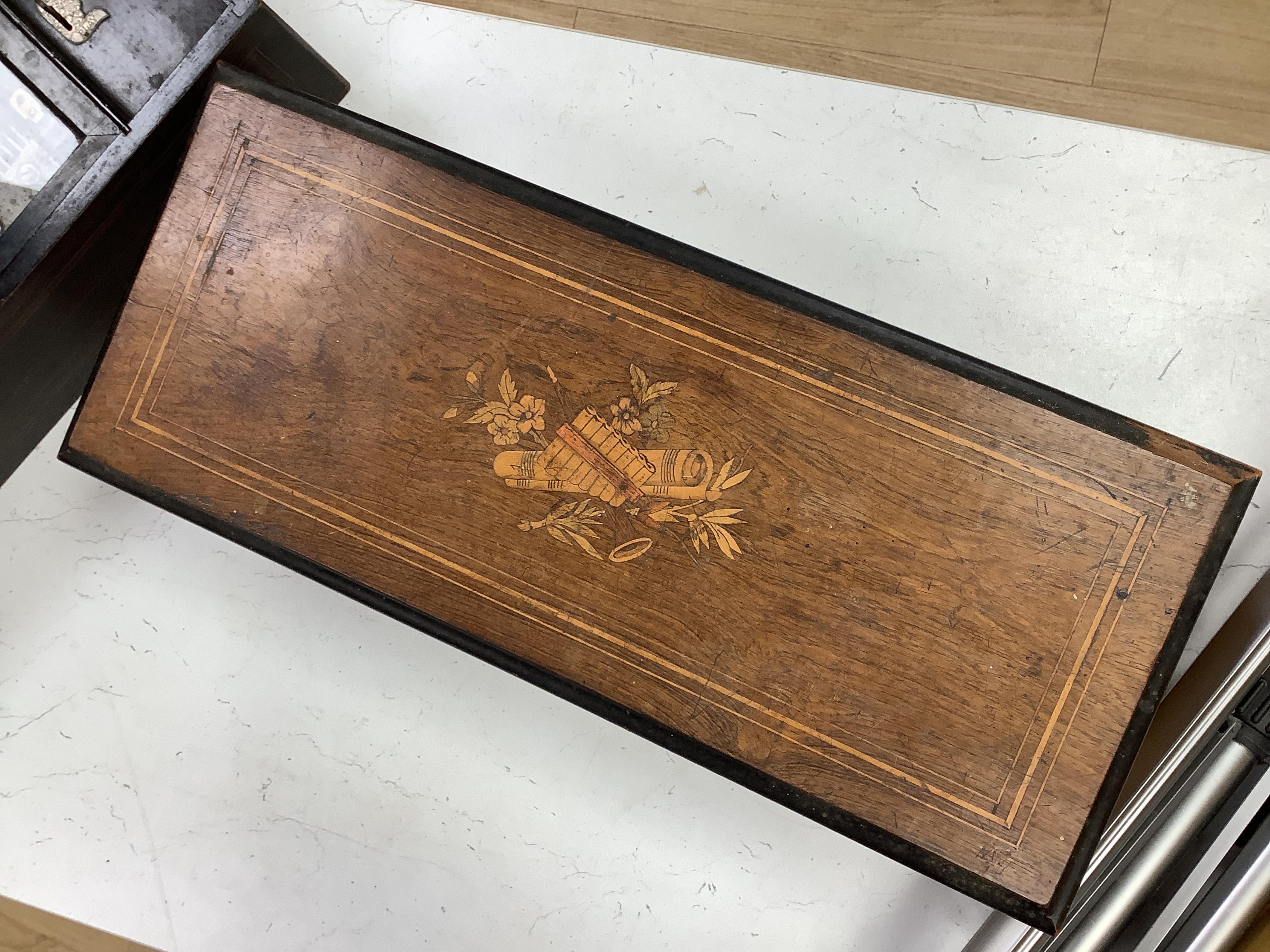 A late 19th century Swiss rosewood ten air cylinder music box, with inlaid lid decorated with musical instruments and foliage, paper label listing the airs to inside of lid, with sixty two tooth comb, cylinder 28cm, case